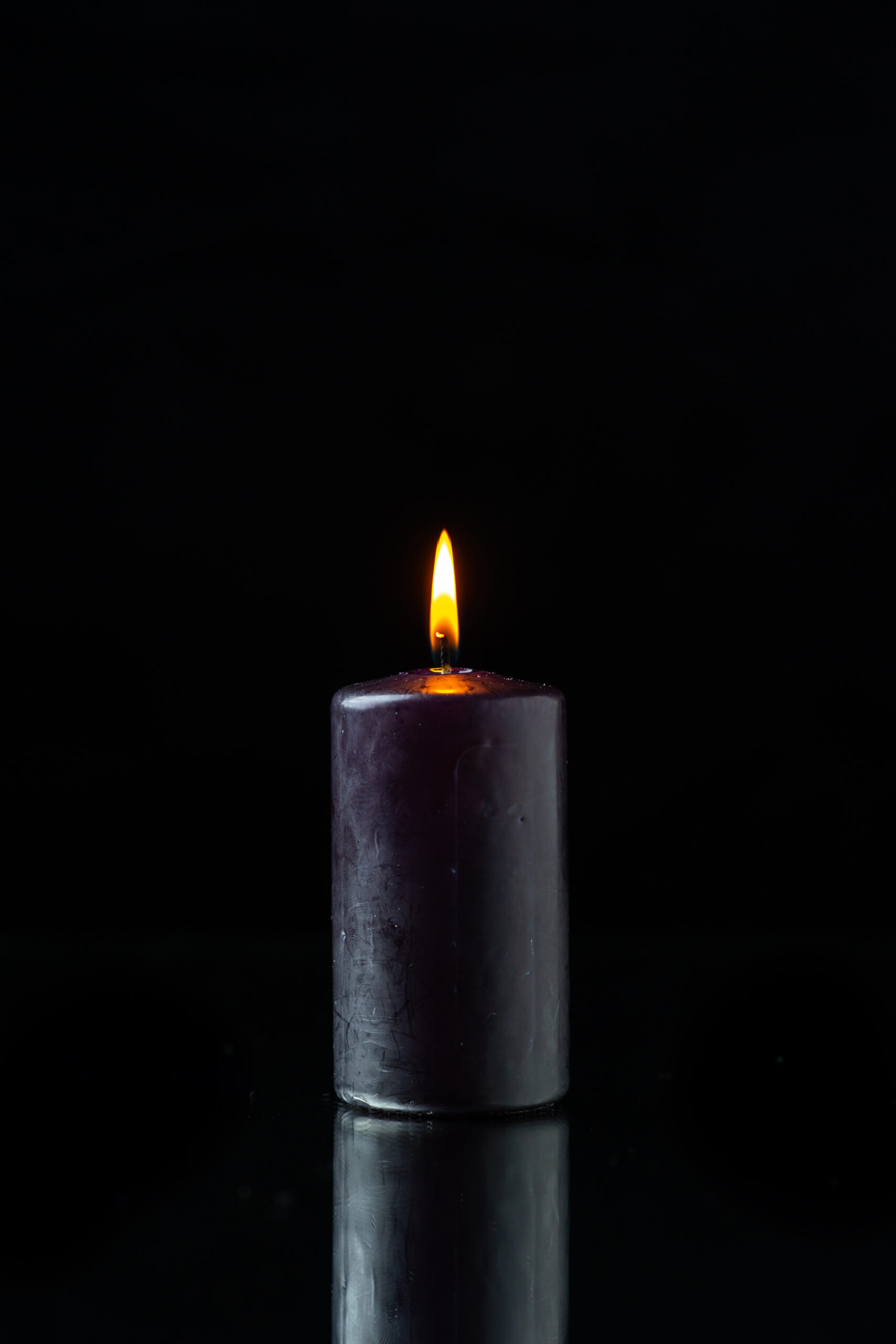 front-view-dark-candle-lighting-dark-surface